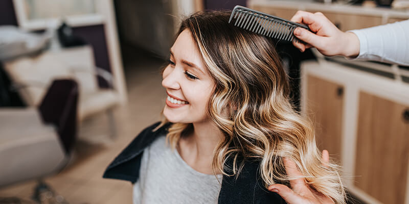 Customer getting hair cut from hair stylist