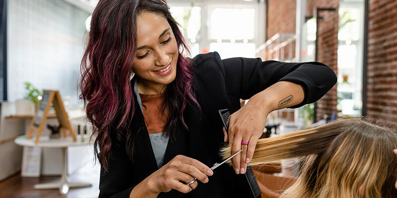 Salon owner cutting hair of a client