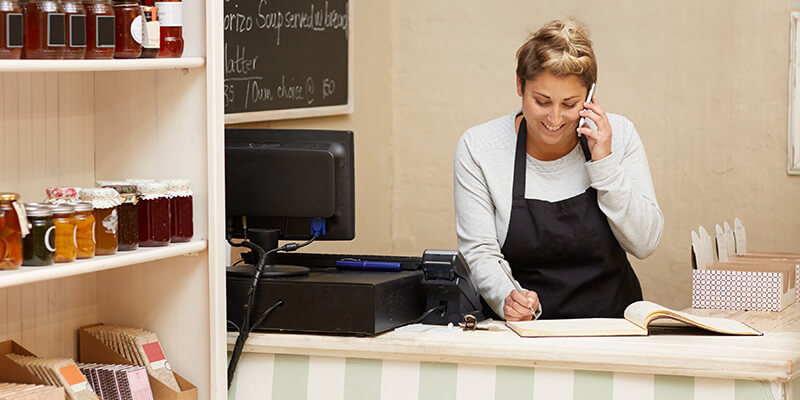 Store owner talking on the phone to a customer